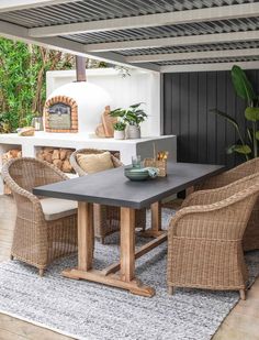 an outdoor dining area with wicker chairs and table