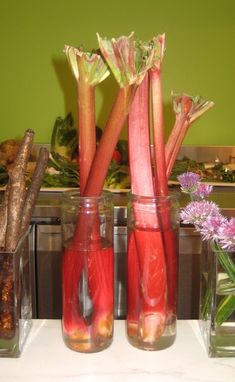 several vases filled with different types of vegetables