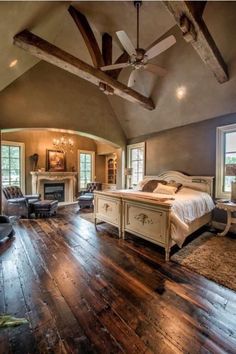 a bed room with a neatly made bed and a ceiling fan in it's center