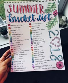 someone holding up a summer bucket list