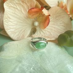 This timeless jade ring features an 18K white gold setting that encases a stunning, highly translucent jadeite cabochon in a sleek bezel arrangement. The centerpiece is a Type A jade cabochon displaying a vibrant apple green.  The remarkable translucency of the jadeite material beautifully complements the subtle pastel hue, enhancing the ring's classic design with an aura of refinement, attributed to the exceptional quality of the jade focal point. Crafted with slightly thicker bezels, the 18K g Modern Jade Gemstone Jewelry, Modern Oval Green Jewelry, Elegant Emerald Jade Ring With Cabochon, Modern Oval Jade Jewelry, Jade Rings With Polished Finish, Oval Cabochon, Jade Rings With Polished Finish In Oval Cabochon Shape, Jade Oval Cabochon Rings With Polished Finish, Oval Cabochon Jade Rings With Polished Finish, Modern Jade Jewelry For Anniversary