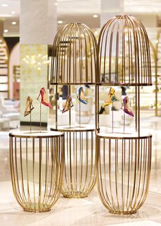 three bird cages with birds in them sitting on top of a marble floor next to each other