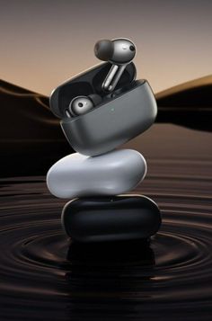 a pair of earbuds sitting on top of a rock in the middle of water