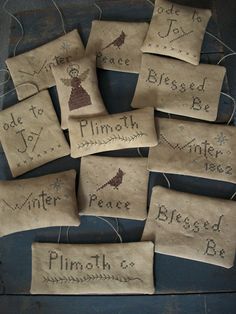 six primitive hand embroidered christmas stockings with words on them, all in different sizes and shapes