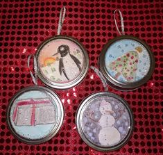 three tin canisters with christmas ornaments in them sitting on a red tablecloth