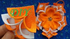 an orange and white hair clip with the word joy on it next to a flower