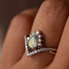 a woman's hand with a ring on it and an oval shaped stone in the middle