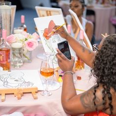 a woman sitting at a table drawing on paper