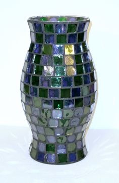 a mosaic vase sitting on top of a white table