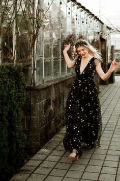 This bestselling style is now back in stock! The Starry Eyed Sequin Star Mesh Maxi Dress is a Confête favorite. Starry Eyed features an a-lined silhouette, deep v-neck, glitter stars and a slight ruffle cap sleeve. Fully lined. Hidden back zipper enclosure. 100% poly. Hand wash cold. Comes in black and gold. Pictured in S and L. Mesh Star Dress, Black Starry Dress, Velaris Starfall Dress, Witchy Wedding Guest Dress, Black Celestial Dress, Celestial Prom Dress, Black Dress With Stars, Black Sequin Bridesmaid Dress, Starfall Dress