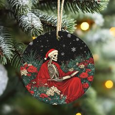 a christmas ornament with a skeleton reading a book on it's side