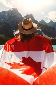 a person sitting on an inflatable raft with the canadian flag draped over their shoulders