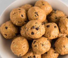 a white bowl filled with chocolate chip cookie doughnuts on top of a table