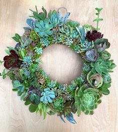 a wreath made out of succulents on a wooden surface