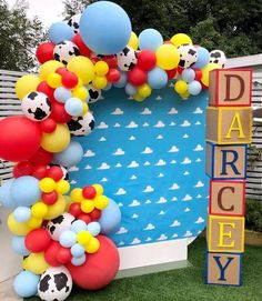 a balloon arch is decorated with soccer balls and balloons in the shape of letters that spell out daddy