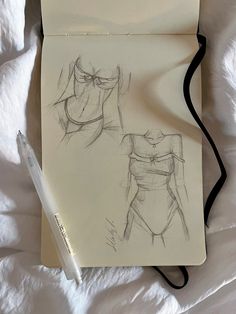 a drawing of a woman's body on top of a sheet of paper next to a pen