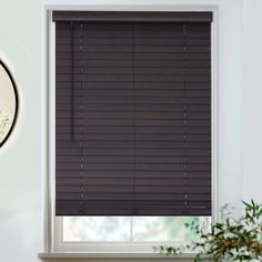 the blinds in this room are made out of dark brown wood and have been pulled down