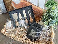 three wine glasses sitting on top of a basket next to a knife, fork and spoon