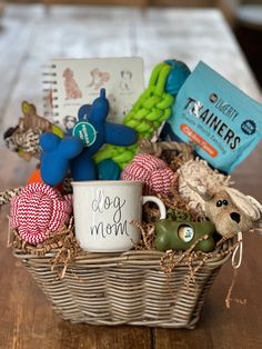 a dog mom gift basket with coffee mug, toys and other items in it on a wooden table