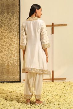 Ivory short kurta with placement floral embroidery using gota patti, dabka, zardozi work. Paired with a salwar with embroidered hem and dupatta with all over geometric pattern and embroidered border. - Aza Fashions White Traditional Wear With Pearl Embroidery For Festive Occasion, Festive White Traditional Wear With Pearl Embroidery, Festive Off White Sets With Pearl Embroidery, White Traditional Wear With Pearl Embroidery For Diwali, Off White Designer Wear Sets For Transitional Season, Traditional Cream Sets With Pearl Embroidery, Off White Designer Sets For Transitional Season, Traditional Off White Sets With Pearl Embroidery, Off White Sets With Pearl Embroidery For Eid