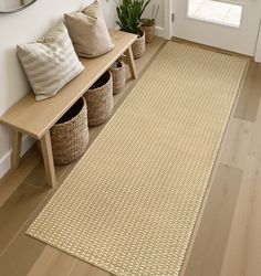 a beige area rug on the floor next to a wooden bench with baskets and plants