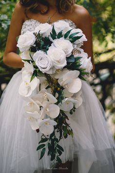 a bride holding a bouquet of white flowers