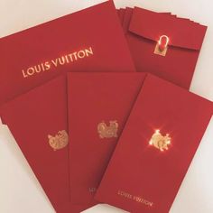 four red louis vuitton folders with gold embellishments on them