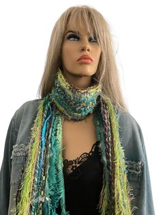 a mannequin head wearing a multicolored knitted scarf with fringes