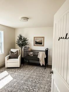 a baby crib in the corner of a room with a chair and rug on the floor