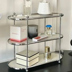 a black table topped with two shelves filled with perfume bottles and other personal care items