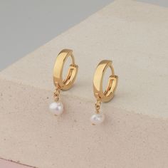 Small hoop earrings with a tiny pearl charm, freshwater pearl on a small hoops earring made of 14k gold filled. These dainty earrings are perfect to wear in the ear lobe, as a first piercing. Minimalist earrings are just perfect and really easy to wear and combine with more earrings. With the latch, backs make them really comfy to wear every day and on every occasion. Hoops size 16mm Pearl charm size 6mm This listing is for a PAIR of hoops earrings. Take a look at the matching necklace: https:// Everyday Pearl Charm Dangle Huggie Earrings, Minimalist Pearl Dangle Huggie Earrings, Minimalist Dangle Huggie Earrings With Pearl Charm, Dainty Huggie Earrings With Dangle Pearl Charm, Dainty Dangle Huggie Earrings With Pearl Charm, Dainty Small Hoop Pearl Earrings With Charm, Dainty Pearl Charm Dangle Huggie Earrings, Gift Pearl Charm Huggie Hoop Earrings, Small Hoop Earrings With Pearl Charm As Gift