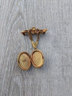 This beautiful Victorian Revival Coro brooch features a coral and cream colored resin cameo of a figure in profile with curling, wavy hair. The cameo is the front face of a locket that dangles by a gold tone metal chain from an openwork floral bar. This classic Midcentury brooch is nicely weighted and wears very well. The piece is in fantastic condition. It shows only minor wear consistent with vintage jewelry. The cameo is firmly in place in its frame. The locket opens and closes smoothly and c Antique Medallion Brooch For Wedding, Victorian Brooches With Locket Pendant, Victorian Locket Pendant Brooches, Vintage Medallion Brooch For Wedding, Vintage Medallion Brooches For Wedding, Ornate Medallion Brooches For Collectors, Ornate Medallion Brooches For Collectibles, Vintage Pendant Brooches For Ceremonial Occasions, Vintage Ceremonial Pendant Brooch