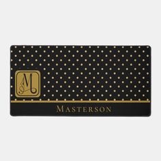 a black and gold polka dot pattern with the letter m on it's front