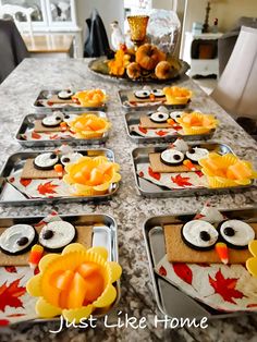 some trays filled with cupcakes on top of a kitchen counter covered in fall decorations