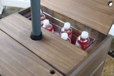 an open wooden box with four bottles in it