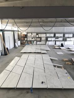 several pieces of white marble are being laid out on the floor in an empty warehouse