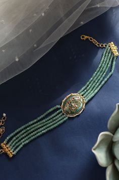 Indulge in elegance with this captivating choker necklace, adorned with exquisite details that set it apart as a unique accessory. Its central focal point showcases an oval jade stone, emitting a soothing mint green hue that exudes tranquility and freshness. The intricate Hauldili work adds delicate patterns and fine detailing, creating a visually appealing contrast against the cool mint green backdrop. Finish: 22KT Gold Plating Material: Silver, Copper Alloy, Onyx, Kundan & Pearl Color: Green S Jade Choker, Hand Jewelry Rings, Chain Braid, Green Backdrops, Jade Stone, Hand Jewelry, Anklet Jewelry, Pearl Color, Charm Gift