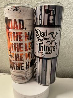 two tumblers sitting side by side on a white counter top, one has the words dad and the other is the king