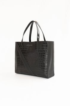 A Christina Karin Exclusive - The Marais Python Tote Inspired by Paris' fashion focused Le Marais district, this python leather tote bag combines modern architectural details with textural intrigue. Generous carry all sizing allows it to fit all your essentials and then some. Make it your travel partner or pair it with a power suit for ease and sophistication. We've designed this tote to go the distance in every modern woman's real life. We invite you to discover the essence of everyday luxury. Modern Crocodile Pattern Shoulder Bag, Modern Satchel With Crocodile Pattern, Modern Crocodile Pattern Shoulder Bag For Daily Use, Modern Shoulder Bag With Crocodile Pattern For Daily Use, Modern Rectangular Satchel With Crocodile Pattern, Modern Crocodile Pattern Satchel, Modern Black Bags With Crocodile Pattern, Modern Shoulder Bag With Crocodile Pattern, Modern Rectangular Bags With Crocodile Pattern