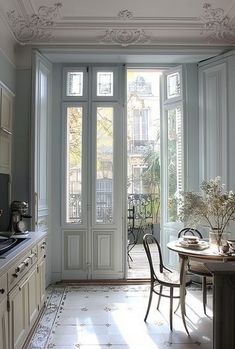 a dining room table and chairs in front of an open door