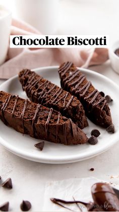 three pieces of chocolate cake on a white plate next to a cup and saucer