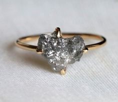 a close up of a diamond ring on a white surface