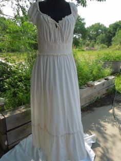 This is a sweet peasant dress made for Old Navy.  It is ankle length and has short sleeves and an elastic waist.  It has a bow tie at the bodice. The size says it's a Large.  It is cotton and it is lined (to the top of the bottom ruffle). Measurements: Shoulder to hem: 48 1/2" Shoulder to shoulder: 11" Waist: 15" (is stretchy) Hips: full Underarm to underarm: 17" Neck to top of elastic waist band: 8" Neck to bottom of elastic waist band: 11 1/2" All my items come from my smoke-free home however because they are vintage they have a prior history I know nothing about.  It is not uncommon for items to show some signs of wear.  I carefully inspect each item and give you an accurate and informed description as much as possible.  If I make repairs I let you know.  If there are rips or stains I a Summer Cottagecore Prairie Dress For Gatherings, Spring Peasant Dress With Short Sleeves, Cream Prairie Dress For Summer Garden Party, Cotton Pastoral Prairie Dress For Summer, Summer Cream Prairie Dress For Garden Party, Summer Garden Party Cream Prairie Dress, Peasant Style Prairie Dress With Smocked Bodice For Summer, Summer Cotton Peasant Prairie Dress, Summer Cotton Prairie Peasant Dress