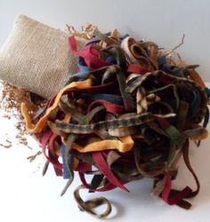 a pile of old cloth sitting on top of a white table next to a burlap bag