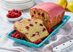 a loaf of raspberry pound cake on a blue plate with raspberries