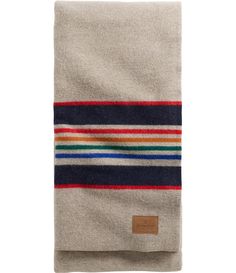 a blanket with multi - colored stripes on the front and back, folded in two different colors