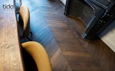 a wooden table with two chairs next to an oven