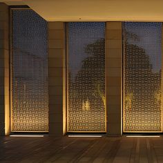 an empty room with three large windows at night