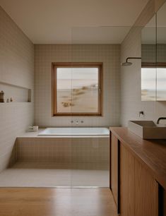 a bath room with a tub a sink and a window