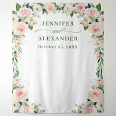 a wedding banner with pink flowers and greenery on the front is hanging from a wall